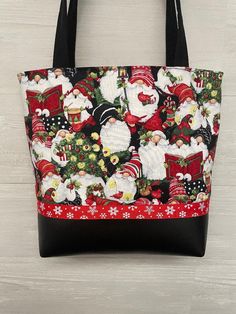 "Christmas Gnomes fabric purse with a black vinyl bottom and ribbon trim. Coordinating inside fabric with 3 pockets and a magnetic snap. 2 matching 27\"  black fabric handles are lined with belting for durability. All Fabric is interfaced for stability Ribbon may vary depending on availability 11.5\"wide. 12\" tall and 3.5\" bottom" Black Fabric Shopping Bag, Quilted Tote Bags Patterns, Christmas Purse, Sew Christmas, Purse Covers, Bags Patterns, Bags 2024, Bags Sewing, Fabric Purse