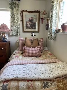 a bed with two pillows on top of it next to a dresser and window sill