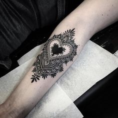 a black and white heart tattoo on the arm