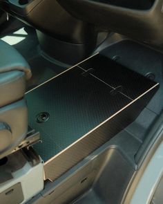 the interior of a car with black leather seats and floor mats, including an automatic gear box