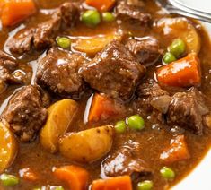 a white bowl filled with beef stew and carrots