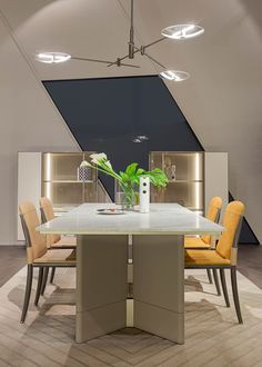 a dining room table with yellow chairs and a white vase filled with flowers on it