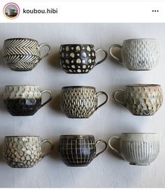 there are many different cups on the wall in front of each other, and one is black and white