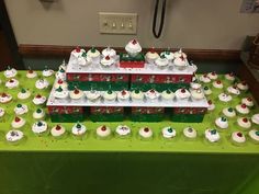 a green table topped with lots of cupcakes