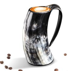 a black and white vase with an orange interior is surrounded by brown speckles