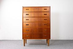 a tall wooden dresser sitting on top of a carpeted floor next to a white wall