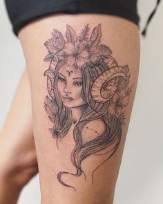 a woman with horns and flowers on her head is shown in this tattoo style photo