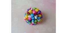 a colorful hair bow on top of a pink surface with polka dots and bows around it