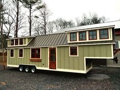 a tiny house is parked in the gravel