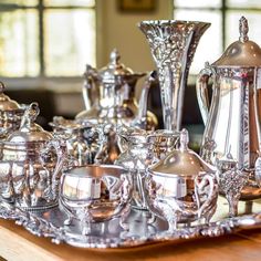 an assortment of silver tea and coffee set on a tray