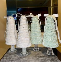 three vases are decorated with white crochet and ribbon, one has a bow on the top