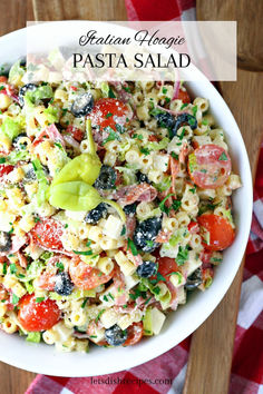 pasta salad in a white bowl on top of a red and white checkered table cloth