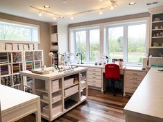 a kitchen filled with lots of drawers and counter top space next to a large window