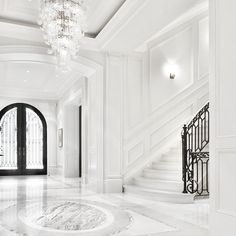 an elegant foyer with chandelier and marble floors