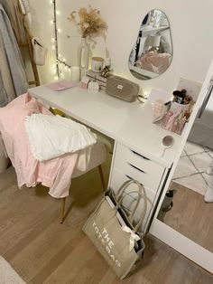 a white desk topped with a mirror and a bag