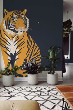 a living room with a tiger mural on the wall and potted plants next to it