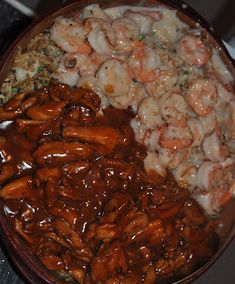 a bowl filled with shrimp and rice covered in sauce