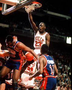 a basketball player dunks the ball in front of his team mates during a game