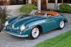 a green sports car parked in front of a building with a brown leather seat cover