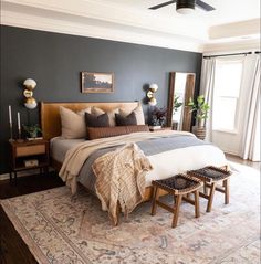 a bedroom with a large bed and two stools