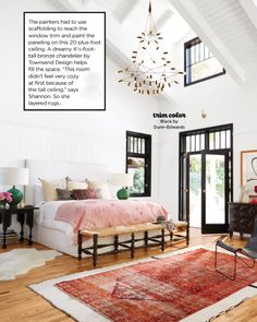 a bedroom with a large rug and chandelier hanging from the ceiling