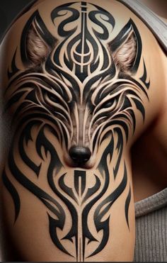 a close up of a person with a tattoo on his arm and shoulder, showing the wolf's head