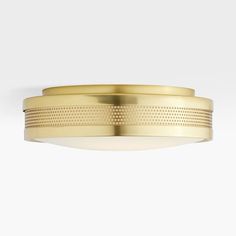 an image of a flush light fixture in gold finish with dim lighting on the ceiling