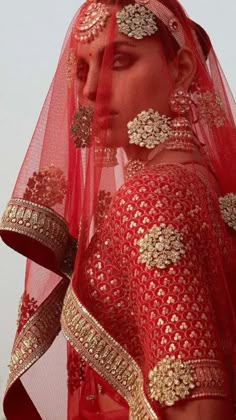 a woman wearing a red and gold bridal veil