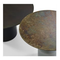 two round metal tables with different colors and sizes on each one, sitting side by side