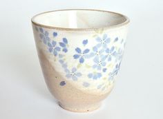 a white cup with blue flowers on it