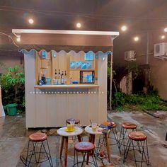 an outdoor bar set up with stools and tables