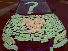 a car covered in sticky notes with a question mark on the hood and tail end