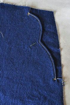 a piece of blue fabric that has been stitched together with pins and thread on it