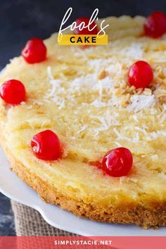 a cheesecake topped with cherries and coconut on a white platter, ready to be eaten