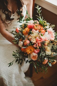 a woman holding a bouquet of flowers in her hands