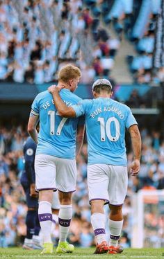 two soccer players are hugging each other on the field