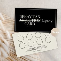 a black and white business card sitting on top of a table next to some feathers