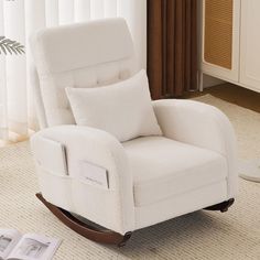 a white rocking chair sitting on top of a carpeted floor