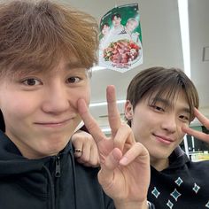 two young men making the peace sign with their fingers