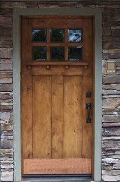 a dog is standing in front of a wooden door with glass panes on it's side