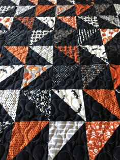 an orange and black quilt is on display