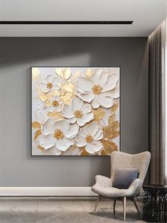 a white and gold flower painting on a gray wall above a chair in a living room