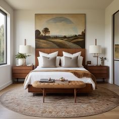 a bedroom with a large painting on the wall and a bed in front of it