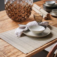 a wooden table topped with plates and glasses