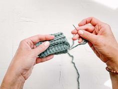 two hands crocheting the ends of a piece of yarn