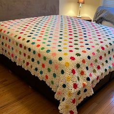 a crocheted blanket on top of a bed in a room with hardwood floors