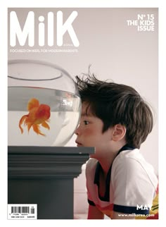 the cover of milk magazine features a young boy looking at a goldfish in an aquarium