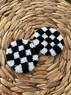 two black and white crocheted buttons sitting on top of a woven basket