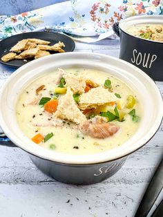 two bowls filled with soup and crackers on a table