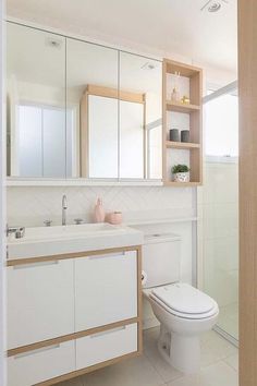 a bathroom with a toilet, sink and mirror